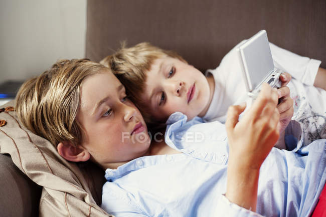 Hermanos jugando en la consola de juegos, enfoque selectivo - foto de stock