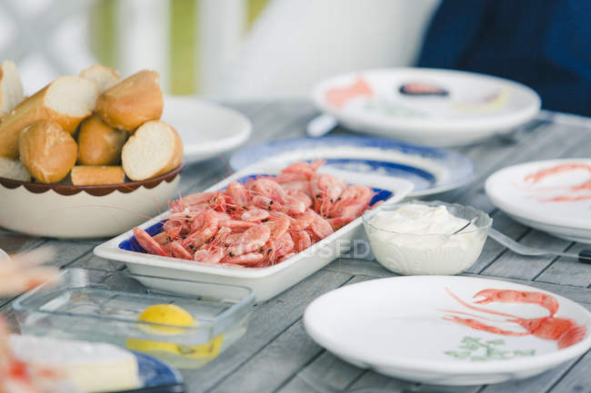 Set wooden table with shrimps and bread — Stock Photo