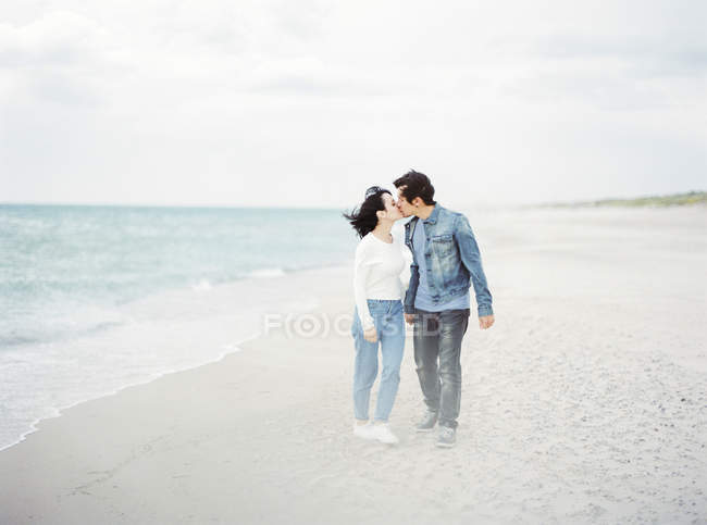 Pareja besándose en la playa, se centran en primer plano - foto de stock