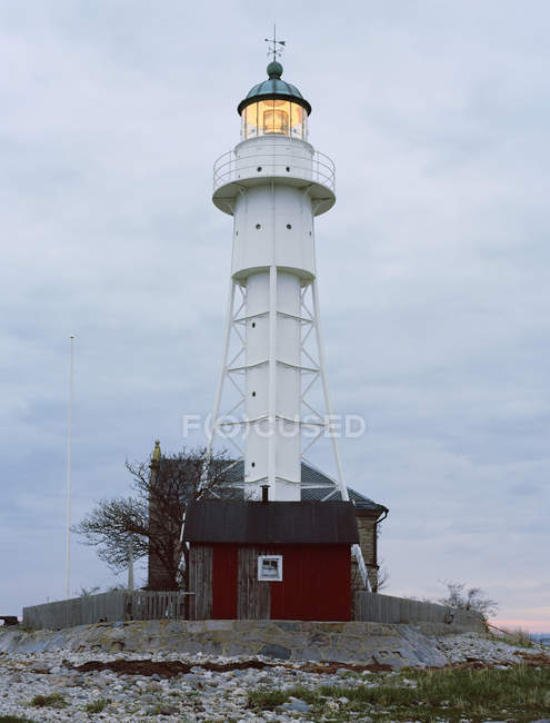 Vue à angle bas du phare illuminé au crépuscule — Photo de stock