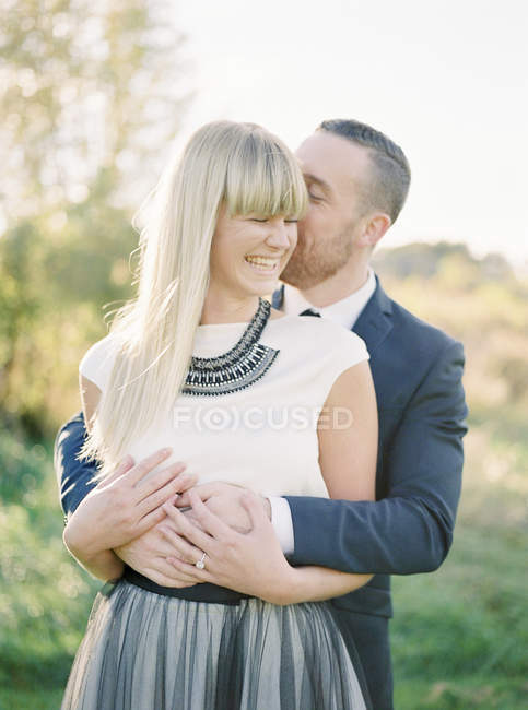 Bräutigam umarmt Braut, Fokus auf den Vordergrund — Stockfoto