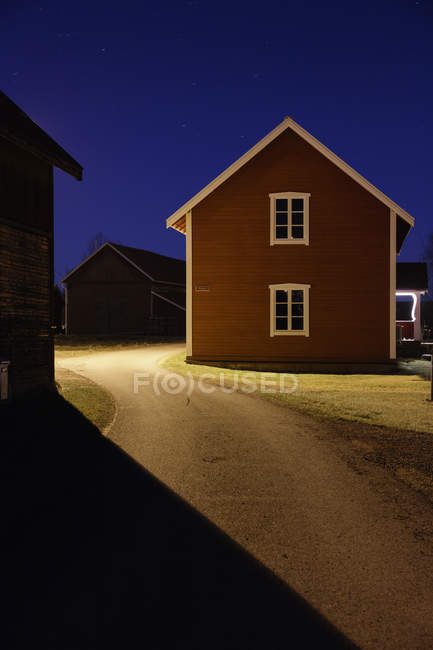 Leere beleuchtete Straße zwischen Häusern in der Nacht — Stockfoto