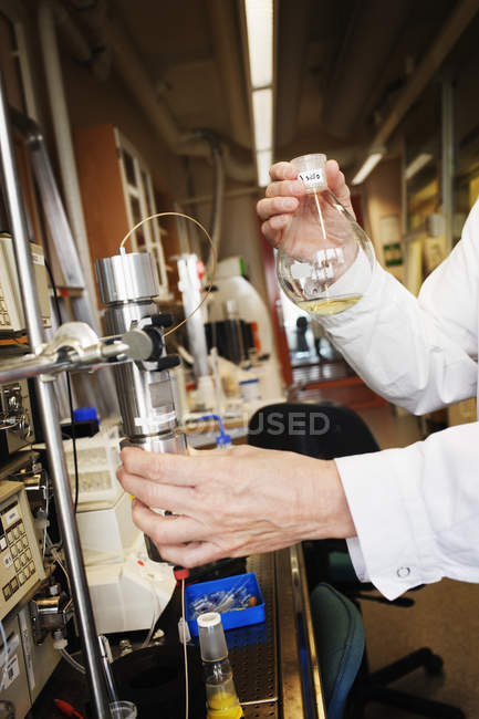 Scientist doing experiment in lab, focus on foreground — Stock Photo