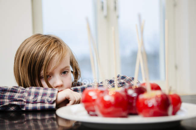 Girl looking at taffy apples, selective focus — Stock Photo