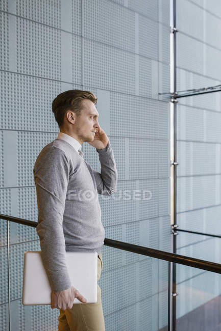 Vista lateral del joven hombre de negocios hablando por teléfono - foto de stock