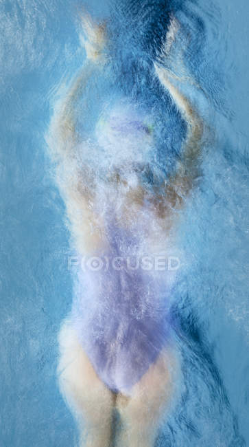 Jeune femme adulte nageant dans la piscine — Photo de stock