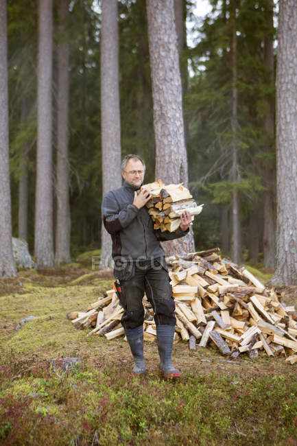 Man carrying firewood, differential focus — Stock Photo