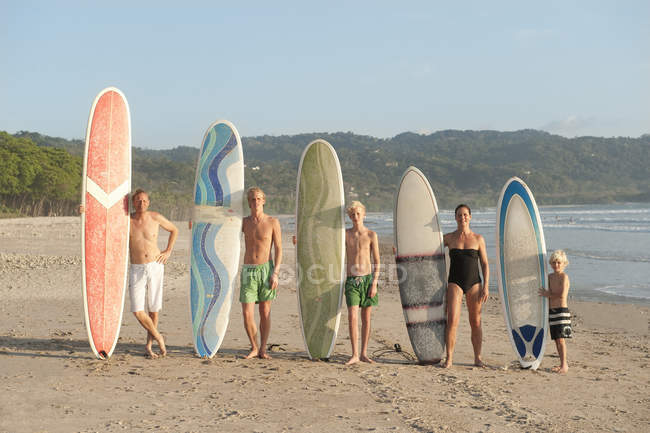 Сім'я з дошками для серфінгу на пляжі, фокус на передньому плані — стокове фото