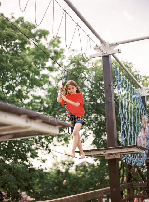 Mädchen läuft auf Seil im Abenteuerpark — Stockfoto