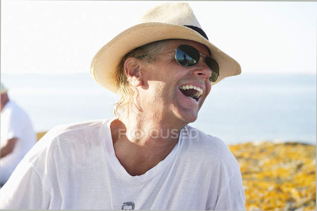 Portrait of smiling man wearing sunglasses and straw hat — Stock Photo