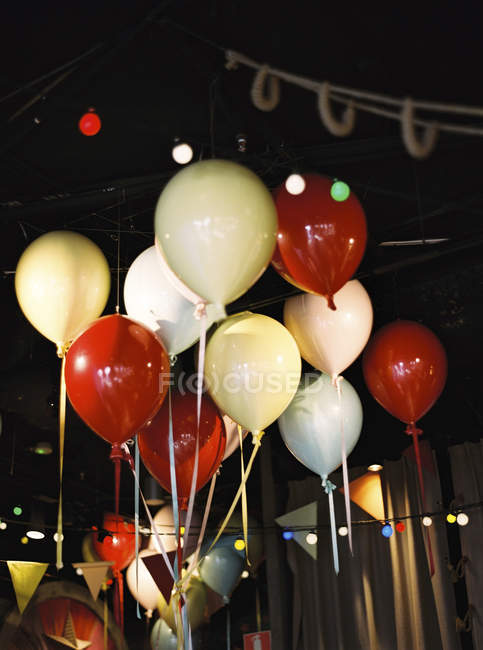 Colorful balloons under ceiling in decorated room — Stock Photo