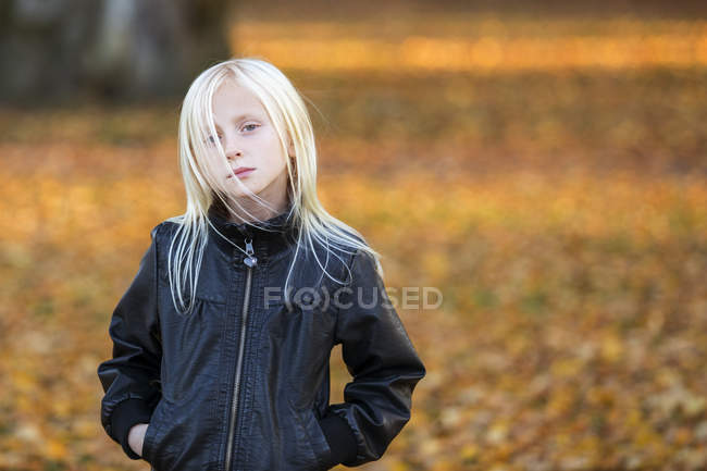 Retrato de menina vestindo jaqueta de couro com folhas de outono no fundo — Fotografia de Stock