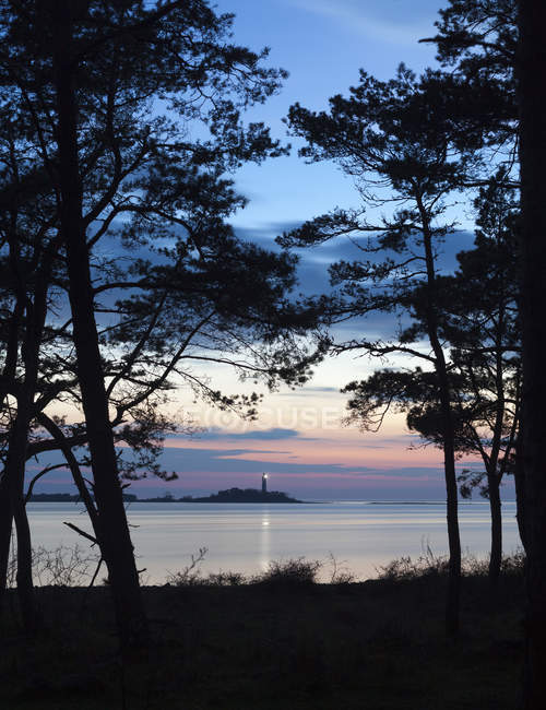 Meereslandschaft mit Leuchtturm in der Abenddämmerung beleuchtet — Stockfoto