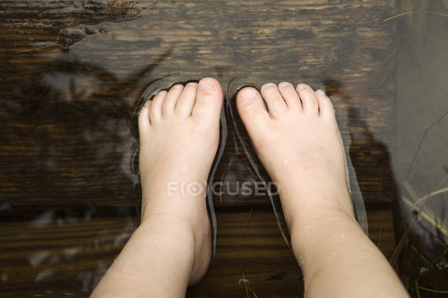 View of girl standing in lake, low section — Stock Photo
