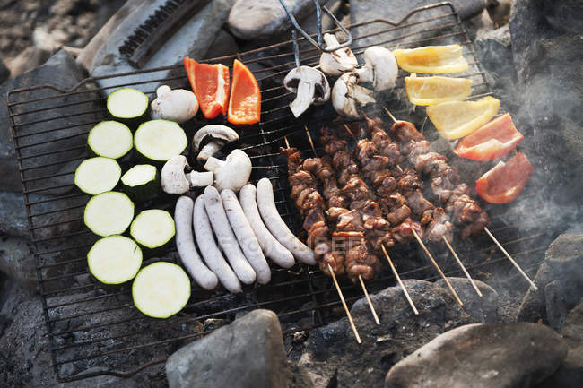 Fresh meat and vegetables cooking on barbecue grill — Stock Photo