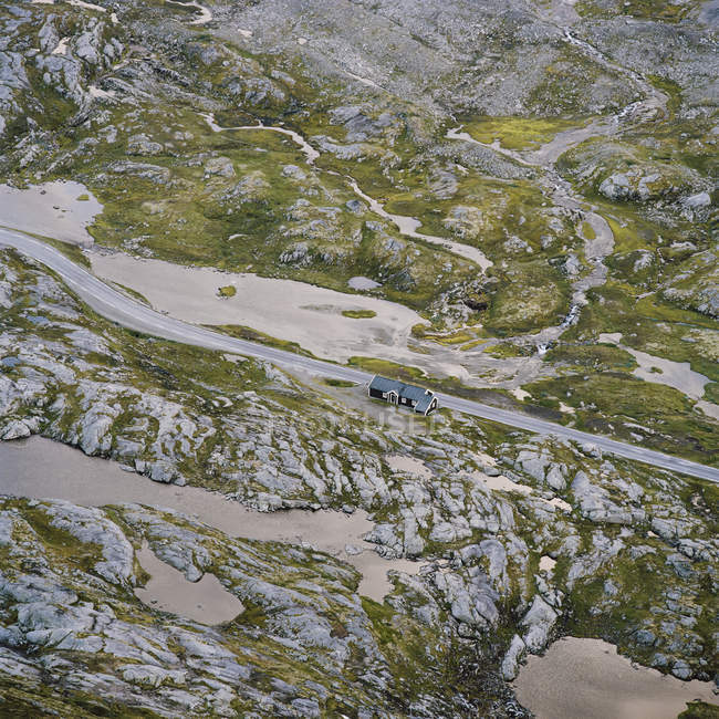 Vista aérea de casa por carretera en las montañas - foto de stock