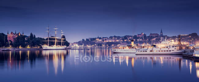 View of harbor and city buildings illuminated at night, Stockholm — Stock Photo