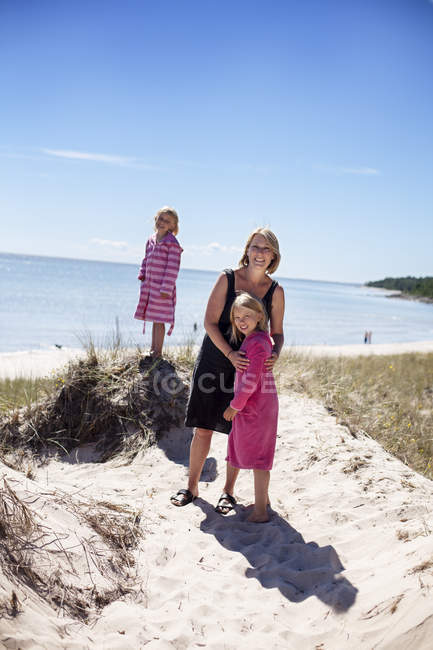 Mother with daughters near sea, focus on foreground — Stock Photo