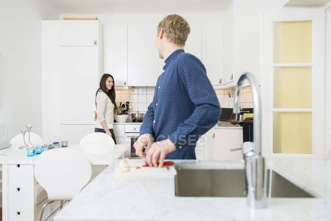 Couple washing dishes in home kitchen, differential focus — Stock Photo