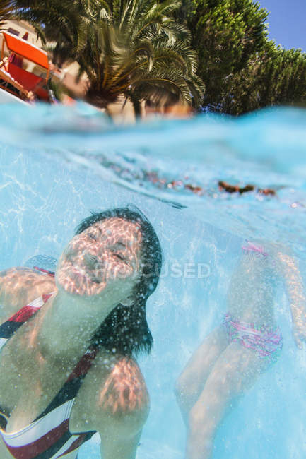 Mother and daughter diving in swimming pool — Stock Photo