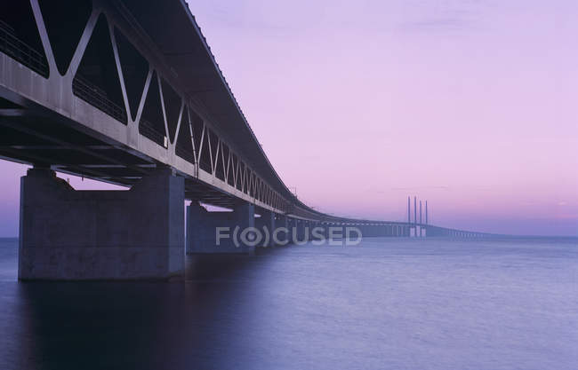 Vista del puente de Oresund en luz púrpura al atardecer - foto de stock