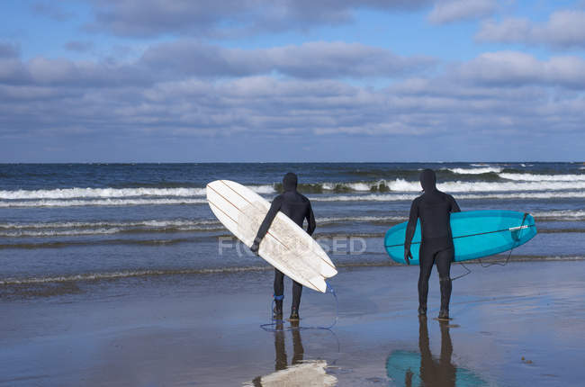 Hombres que van a surfear a Bondi Beach al amanecer - foto de stock