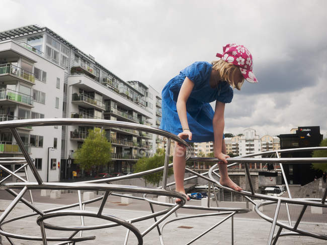 Side view of girl climbing on metal installation — Stock Photo