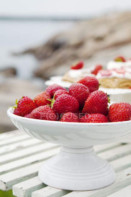 Morangos em tigela de frutas brancas na mesa — Fotografia de Stock