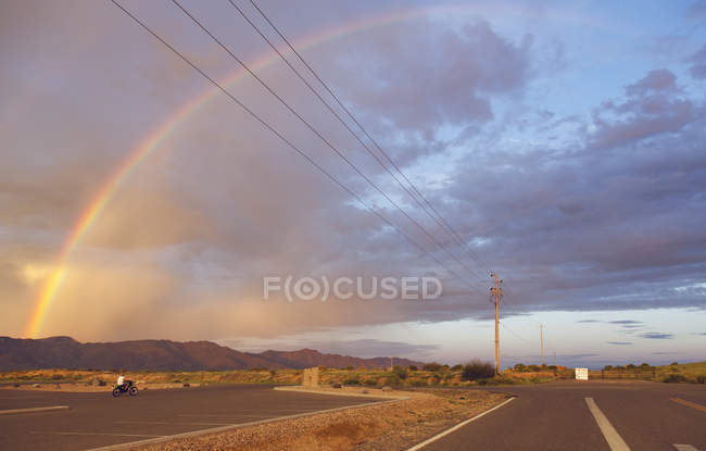 Scenic view of rainbow over mountains at sunset — Stock Photo