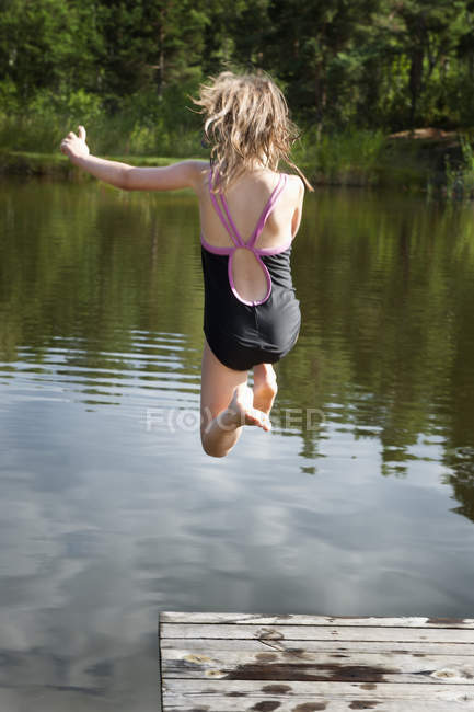 Дівчина-підліток стрибає у річковій воді — стокове фото