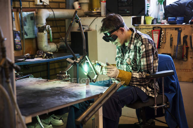 Young man in protective eyewear welding metal — Stock Photo