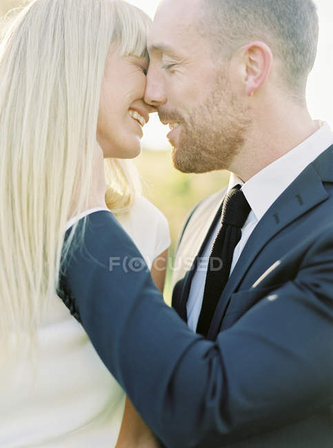 Groom and bride kissing, focus on foreground — Stock Photo