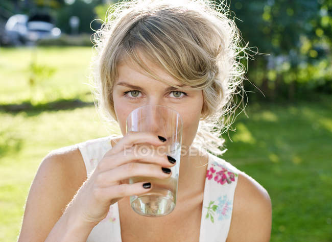 Молодая женщина наслаждается холодным напитком, избирательный фокус — стоковое фото