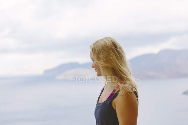Mujer rubia mirando el mar en Kalymnos, Grecia - foto de stock