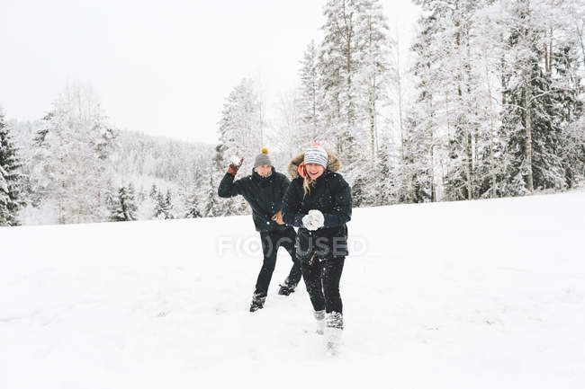 Young couple having snowball fight — Stock Photo