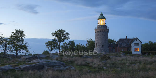 Мальовничим видом маяк висвітлюватися в сутінках, Данія — стокове фото