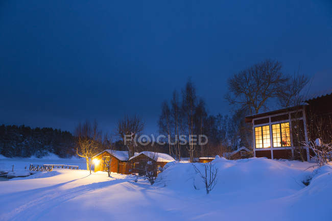 Fienili e casa residenziale nel paesaggio innevato di notte — Foto stock
