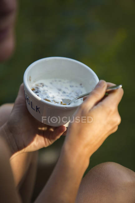 Frau hält Teller mit Müsli mit Milch — Stockfoto
