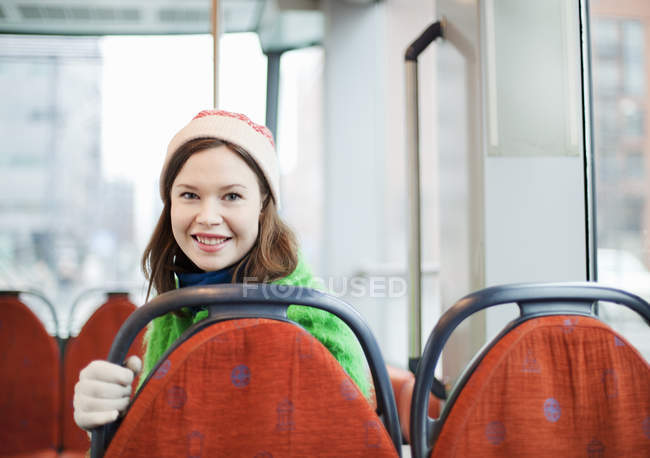 Mujer joven detrás del respaldo del asiento en tranvía - foto de stock