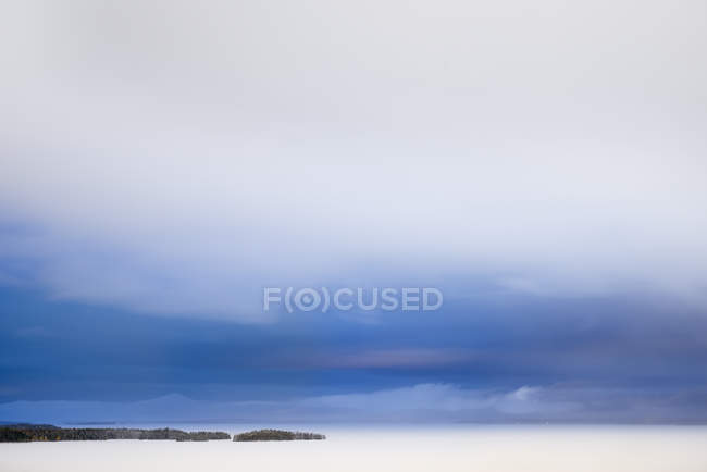 Tiro exposição longa de água do lago sob céu nublado — Fotografia de Stock