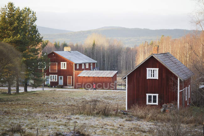 Rote Holzhäuser in herbstlicher Landschaft — Stockfoto