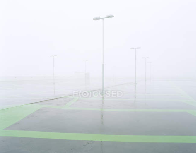 Estacionamiento vacío cubierto de niebla - foto de stock