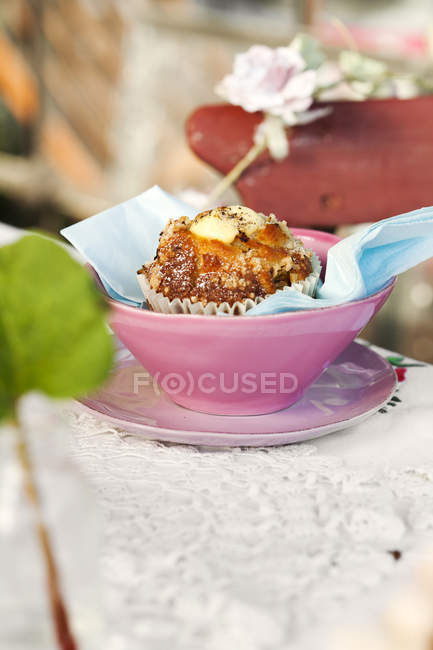 Süßes Brötchen in rosa Tasse auf dem Tisch — Stockfoto