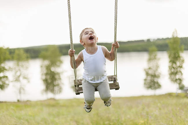 Boy playing on swing, selective focus — Stock Photo