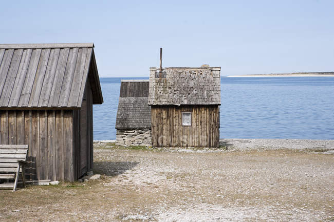 Edifici in legno sulla costa del mare sotto il cielo blu — Foto stock