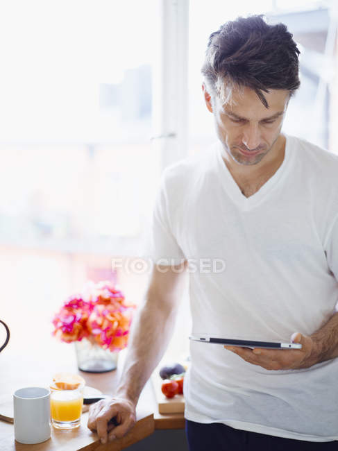 Человек, использующий цифровой планшет дома — стоковое фото