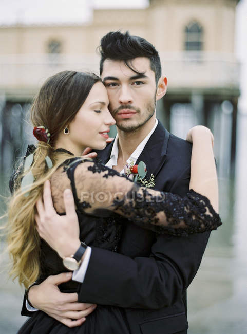 Jeune couple habillé formellement câlin — Photo de stock