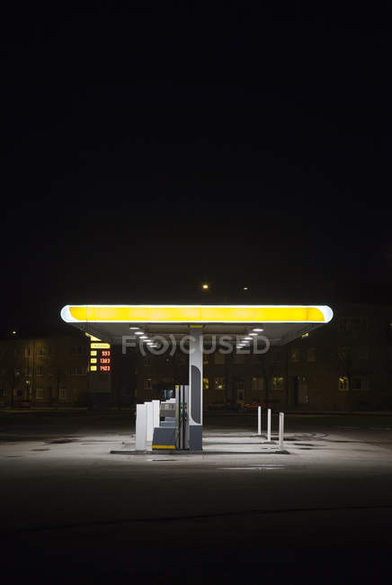 Vista de la gasolinera iluminada por la noche - foto de stock