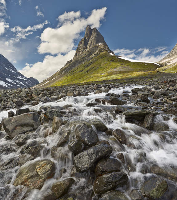 Arroyo de agua rocosa al pie de las montañas en Laponia - foto de stock