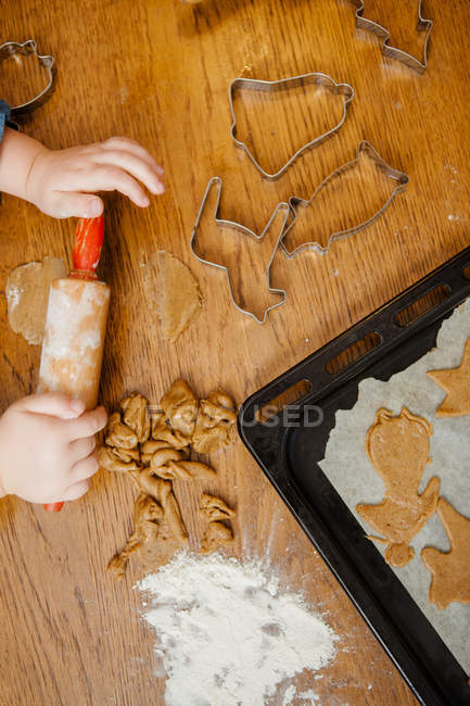 Обрезанный снимок маленьких девчачьих рук, делающих печенье — стоковое фото